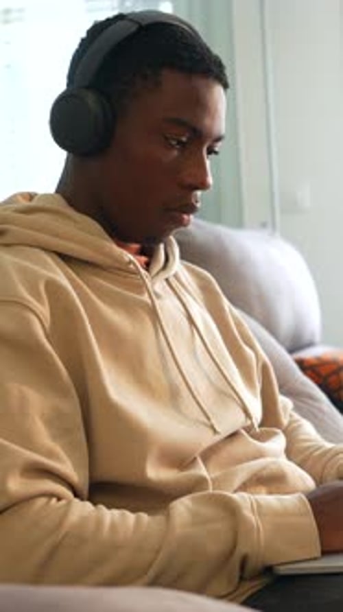 Young Adult Using Laptop Indoors on Couch