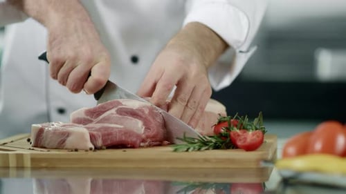 Chef Cuts Raw Meat on Wooden Cutting Board