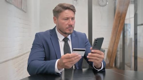 Man in Suit using Smartphone and Credit Card