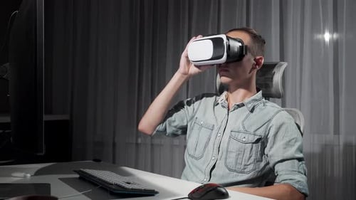 Young Adult Puts On VR Headset in Office