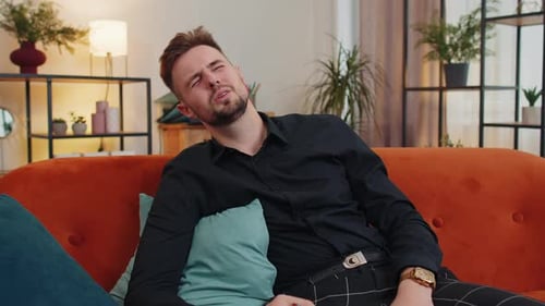 Sad Young Adult Man Sitting on Couch