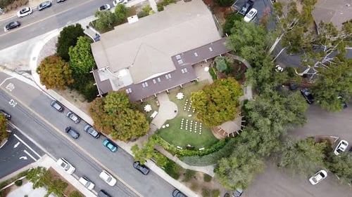 Top Down Aerial view of an outdoor wedding celebration setup with white chairs on a green lawn, in R