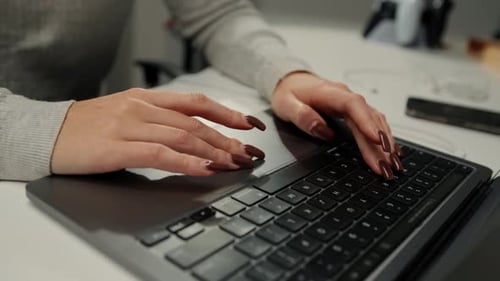 Close-up of a laptop: a girl works at a computer, uses a touch pad