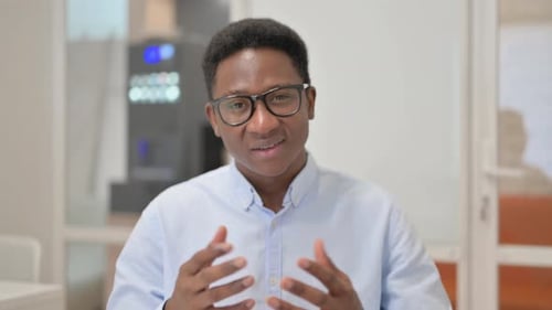 Blogging African Businessman Doing Video Chat in Office