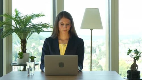 Woman Working on Laptop at Office Desk