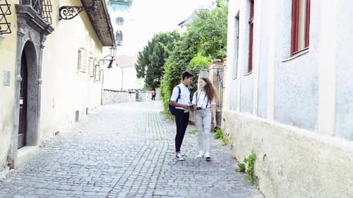 Young Adults Exploring City with Map on Cobblestone Street