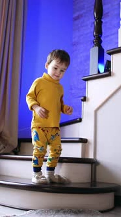 Young Boy Climbing Stairs in Colorful Pajamas