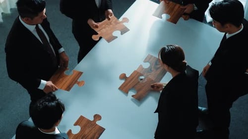Top view of businesspeople putting jigsaw together at meeting room. Directorate.