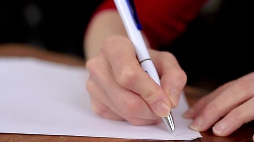 Frau schreibt Notizen auf einem Bürotisch — Stockvideo-Stockfilmmaterial