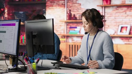 Woman Wearing Headset Using Computer at Modern Office