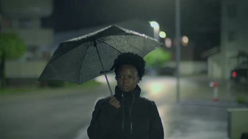 Woman Walking with Umbrella in the Rain at Night