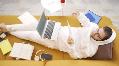 Man Works From Home Lying on Couch