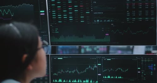 Woman Engages With Stock Data on Multiple Analytical Displays in Vast Innovative Digital Hub