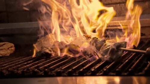 Chef Preparing BBQ Meat in Kitchen Grill on Open Fire Closeup