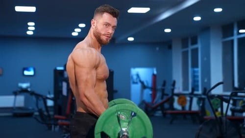 Muscular Man Lifting Weights in Gym