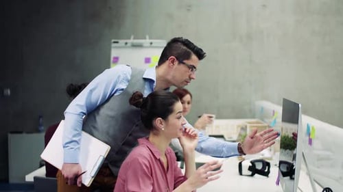Diverse young business team collaborating on project in modern office environment