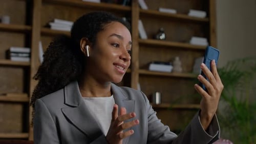 Young Woman in Suit Talking on Phone in Home