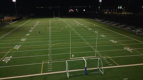Football Field with Soccer Players at Night Top View