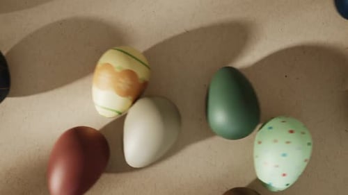 Top view of colorful Easter eggs rolling on paper background.