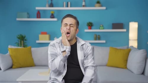 Man Grips Face in Toothache Pain