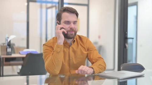 Man Using Phone and Talking in Office