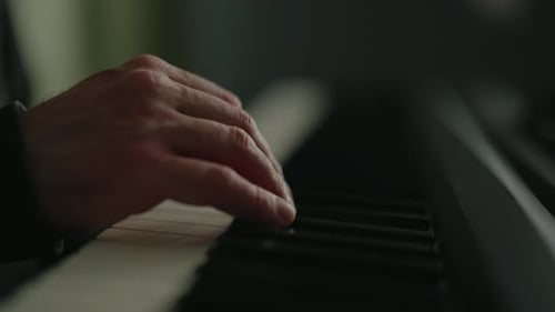 Side View of Musician Hand Gracefully Gliding Over Keys of Electric Piano Creating Music in Dark