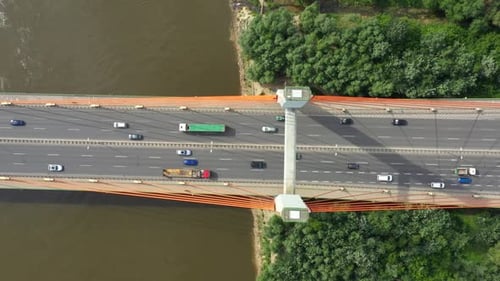 City car moving at highway bridge on background smooth river surface drone view