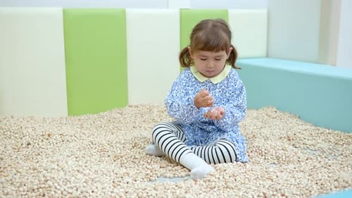 Kids Cafe - 3-year-old Mixed-race Little Girl Playing Wooden Blocks Sand Pool At Indoor Playroom.