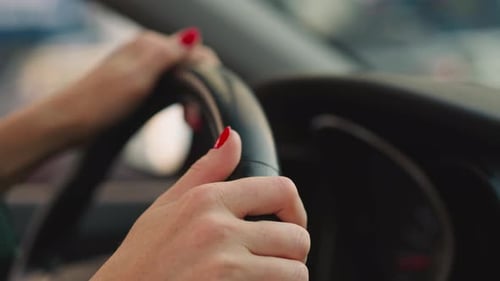 Woman Driving Car with Hands on Steering Wheel