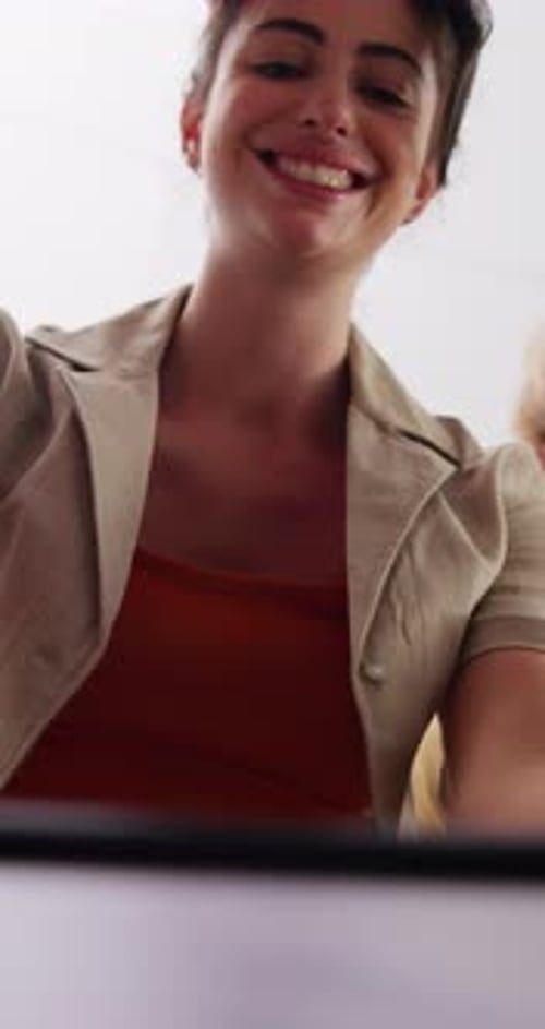 Smiling Young Woman Unpacking Box With Friend Indoors