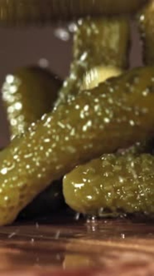 Pickled Cucumbers Fall on a Wooden Table Filmed on a Highspeed Camera at 1000 Fps