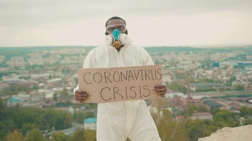 Person Holding Coronavirus Crisis Sign on Hilltop
