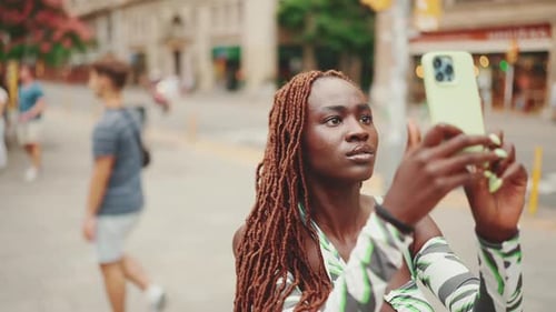 Woman Taking Photos with Cell Phone in City