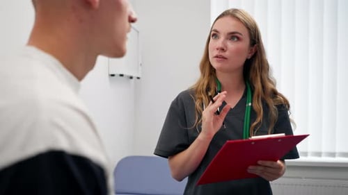 Close Up in a Modern Clinic in a Small Therapist s Office a Young Girl Doctor with a Stethoscope is