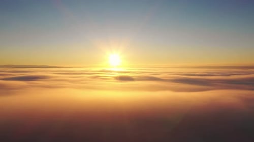 Aerial View of Sunrise Above the Clouds