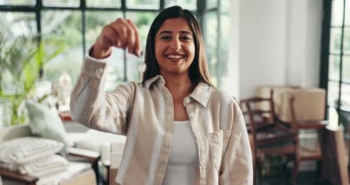 Face, moving and woman with keys, smile and proud of investment with new home, mortgage and lounge