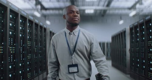 Big Data Center with Server Racks and Internet Servers Specialist Walking In Warehouse