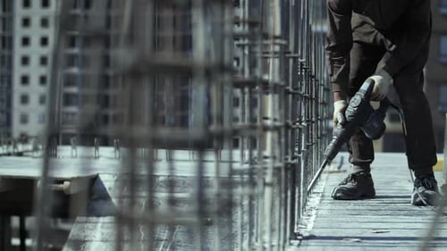 Construction Worker Building with Drill on Site
