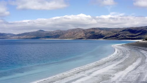 Scenic view to Turkish hills over deserted white beach and turquoise Lake