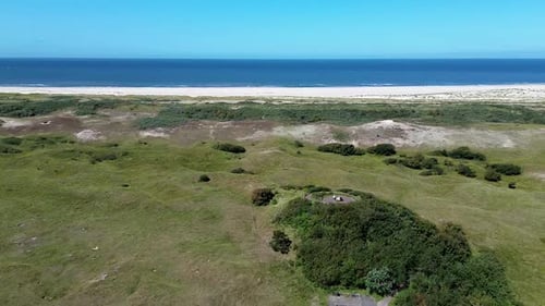 Top view of the beach kijkduin and sea. Flight over fields with green grass and buildings on the sea