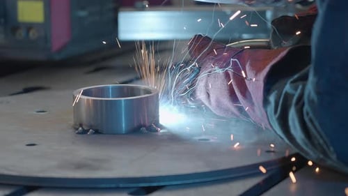 Welder Connecting Metal Cylinder with Sparks