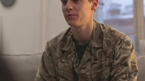 Young Adult Soldier Conversing on Couch Indoors