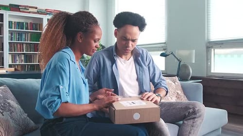 Young Couple Opening Delivery Package in Sunny Home