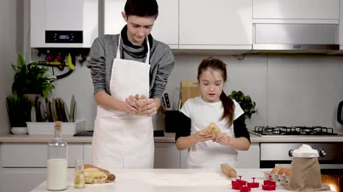 Mädchen und Junge formen Teigstücke in der Küche, Kinder backen Kuchen, Kinder haben Spaß, Kinder
