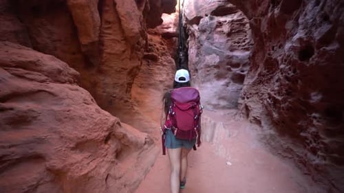 Female Hiker WIth Backpack Walking Into Narrow Canyon, Hiking Trail in St. George Narrows, Utah USA