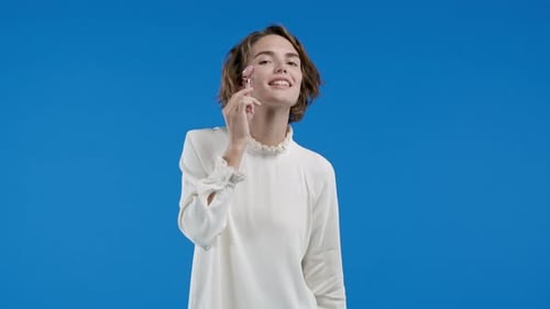 Woman Using Beauty Roller on Face