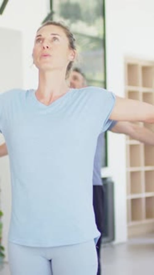 Mulher seguindo o sinal de inspiração, estendendo os braços para cima para se exercitar em casa em meio à lenha, homem espelhando