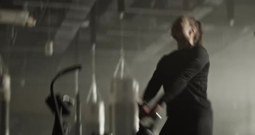 Motivated Sportswoman Doing Kettlebell Swing Exercise in Gym