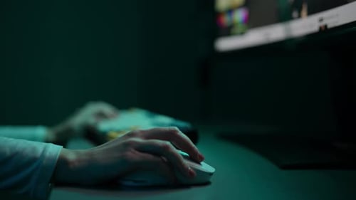 Hands operating computer mouse with RGB lighting