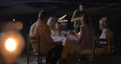 Waiter serving dinner for family in outdoor cafe
